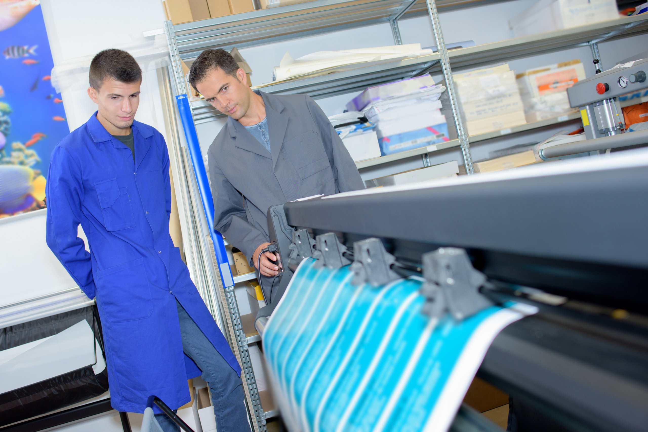 Two men overseeing profesisonal printing machine